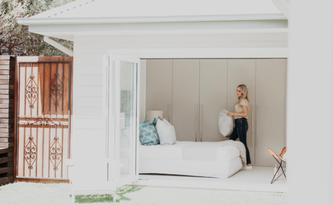 Property stylist walking to place pillow on bed